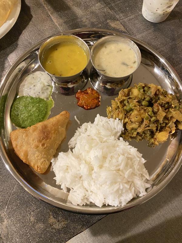 A traditional thali with samosa, rice and chutneys