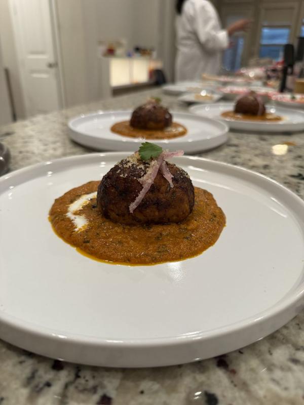 Kofta plated over a spiced sauce